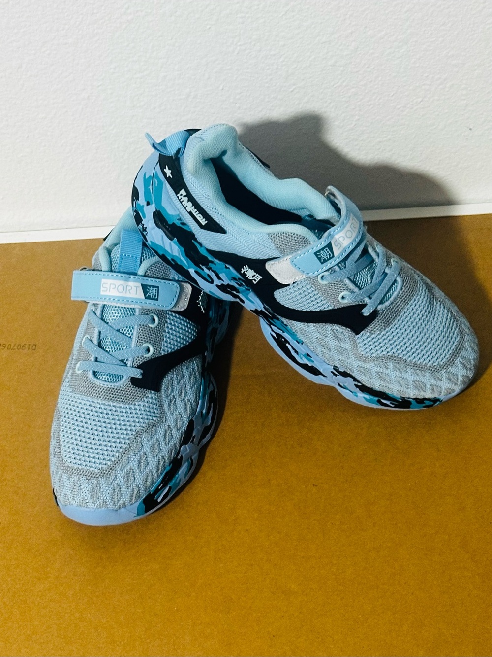 Light Blue Kids Sneakers with Black Accents and Camouflage Sole